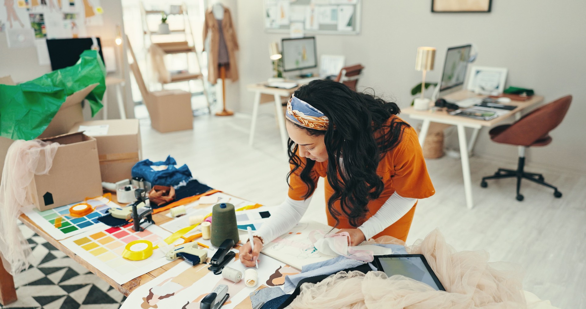 Fashion designer, woman and sketch at desk for planning clothing design and choosing fabric for product sample. Small business, entrepreneur and draft template for creative inspiration or sewing info